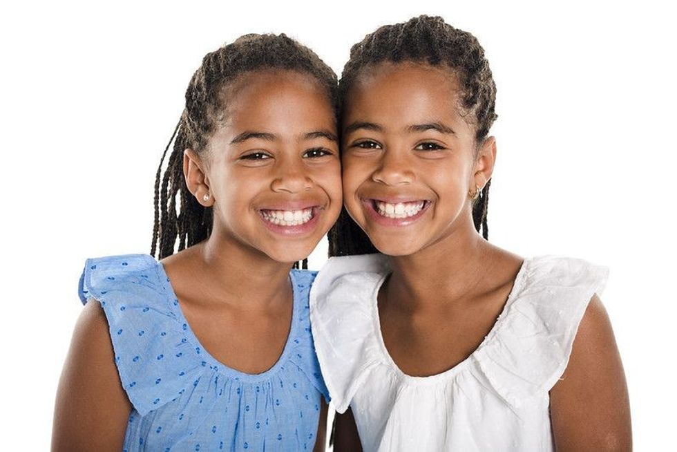 Adorable african twin girl on studio white background.