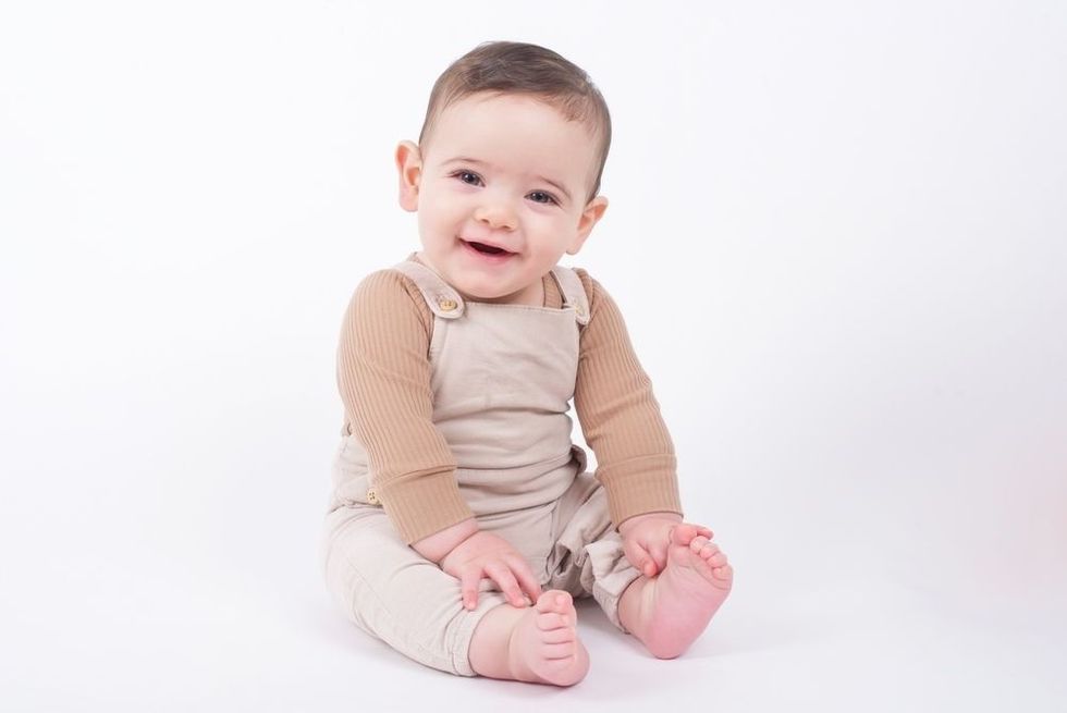 Adorable lebanese baby boy wearing beige overalls 