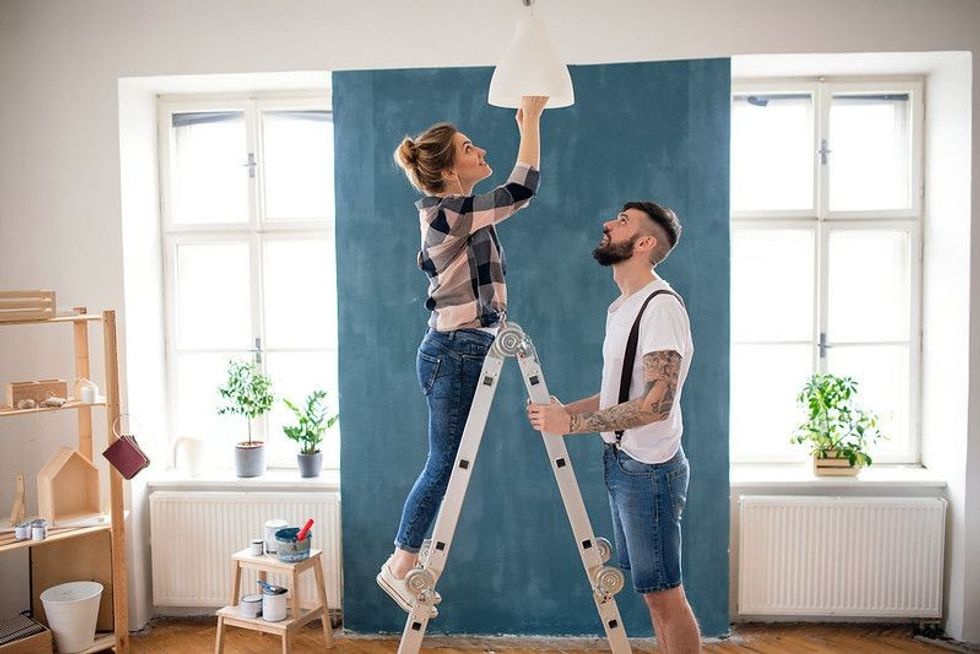 Adult couple changing bulb in their house.