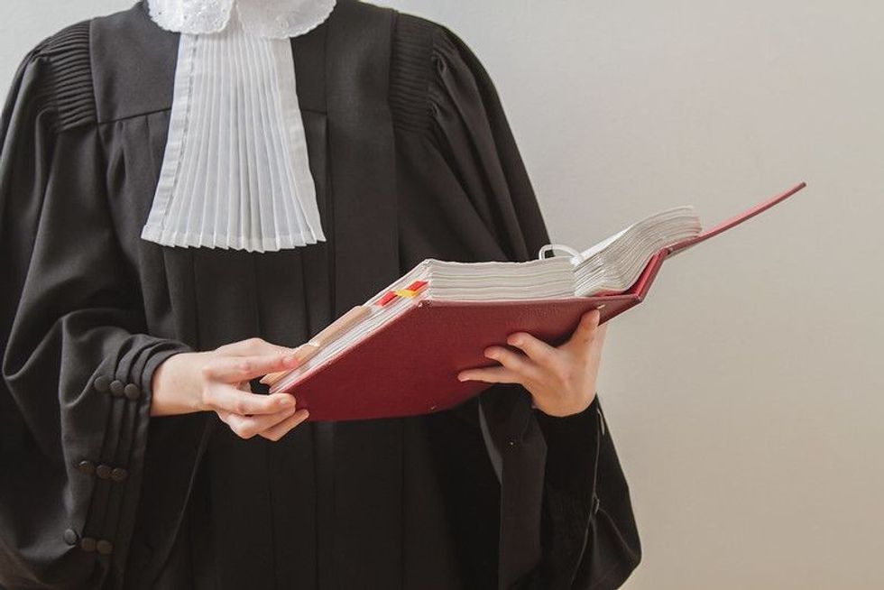 Advocate in toga reading from a red law book