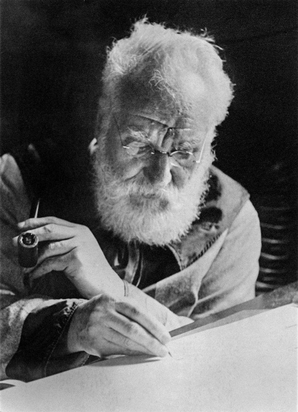 Alexander Graham Bell writing at his desk