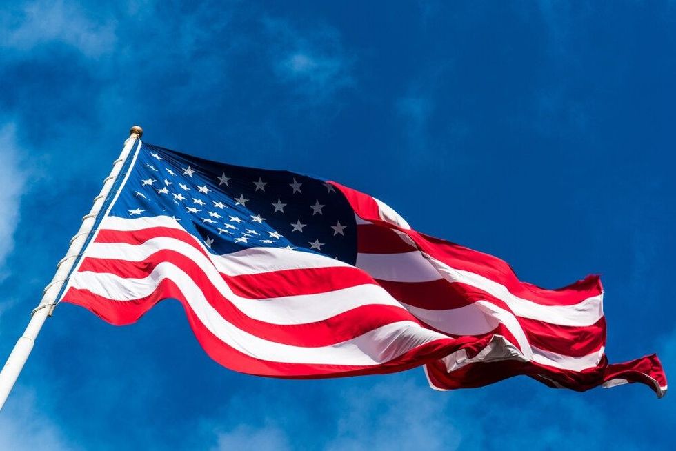 American flag hoisted with the backdrop of the sky