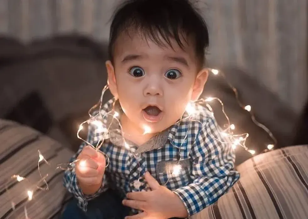 An adorable baby boy wearing fairy lights