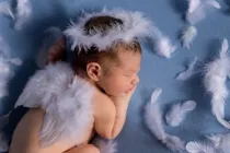 An angel newborn baby with wings and halo sleeping