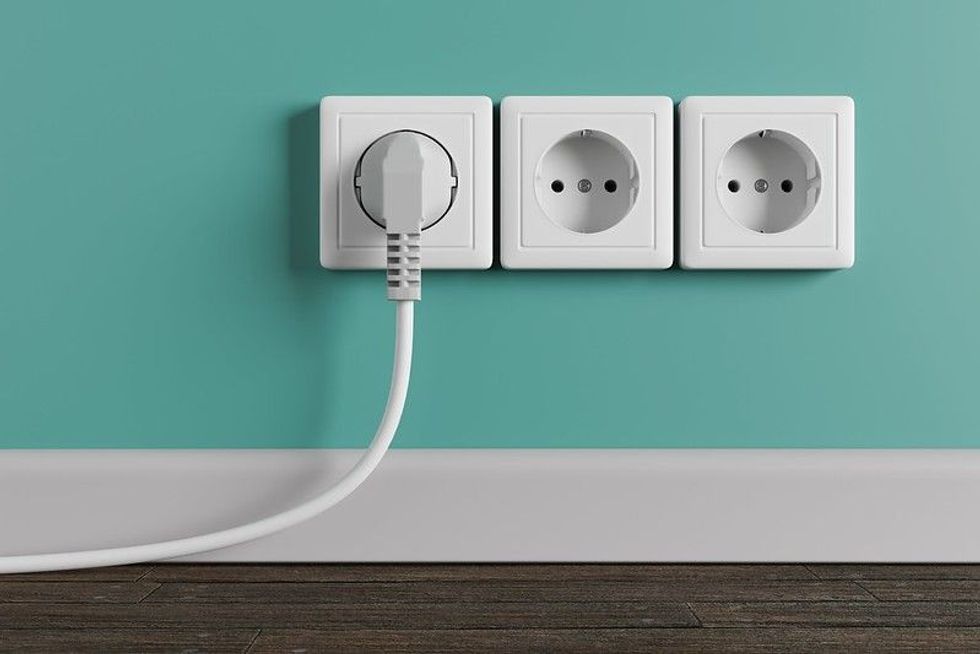 An electric plug with a cable in the socket.