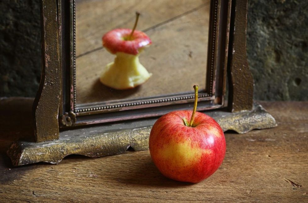 Apple shown in mirror with different perspective.