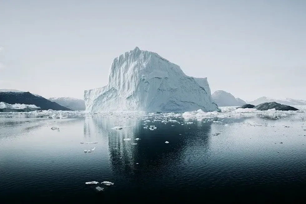Arctic iceberg in Greenland, the water looks dark in contrast to the ice.