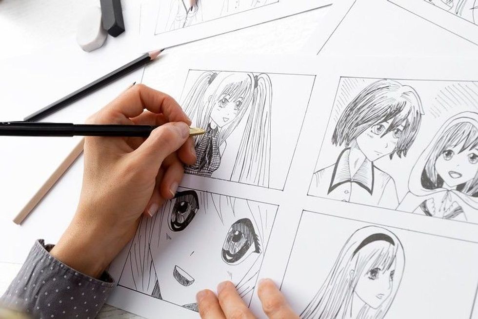 Artist drawing sketches of anime comic characters