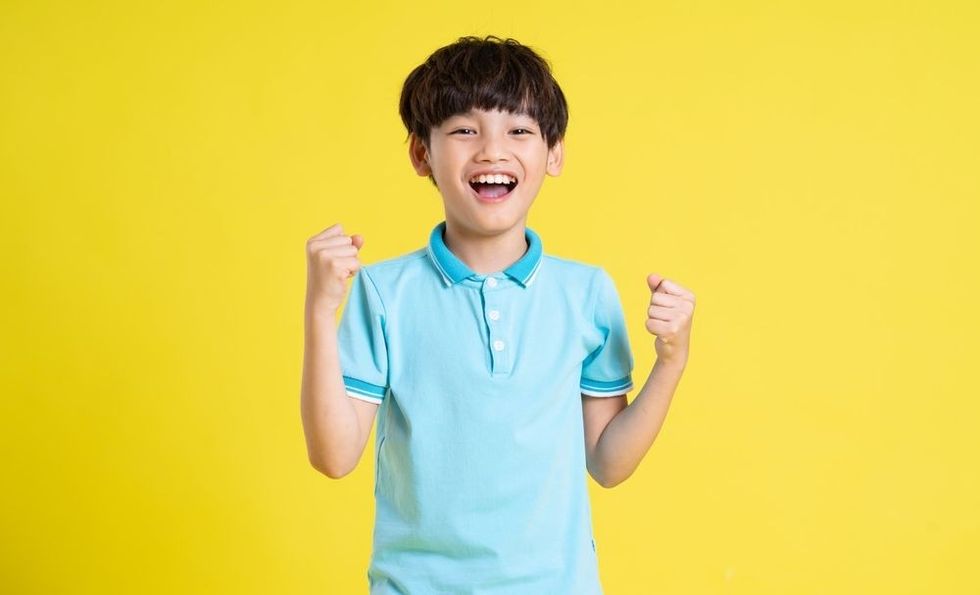 Asian boy posing on a yellow background