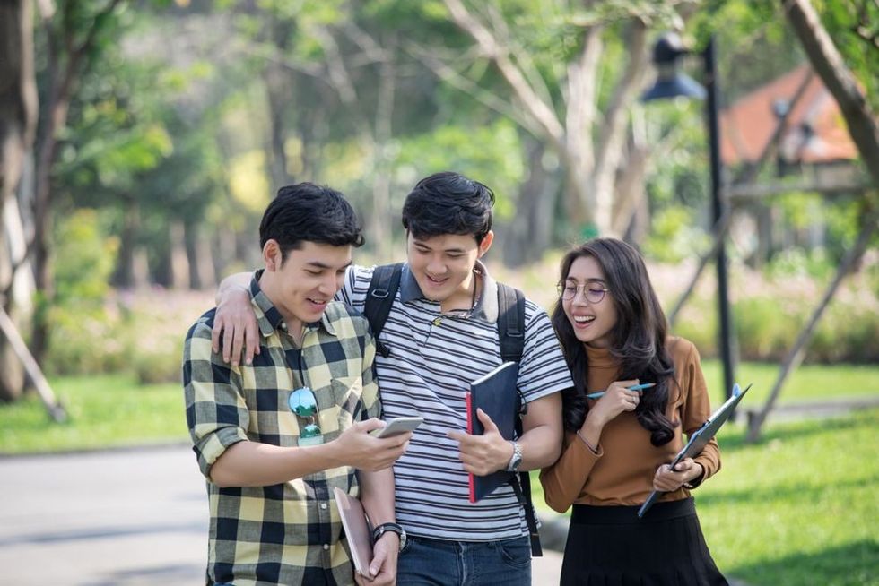 Asian high school talking and using social media for homework and hobby, modern age education learning concept.