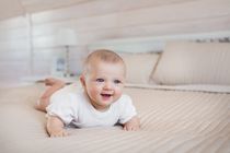 Aspen little baby lies and smiles on a bed  - Nicknames