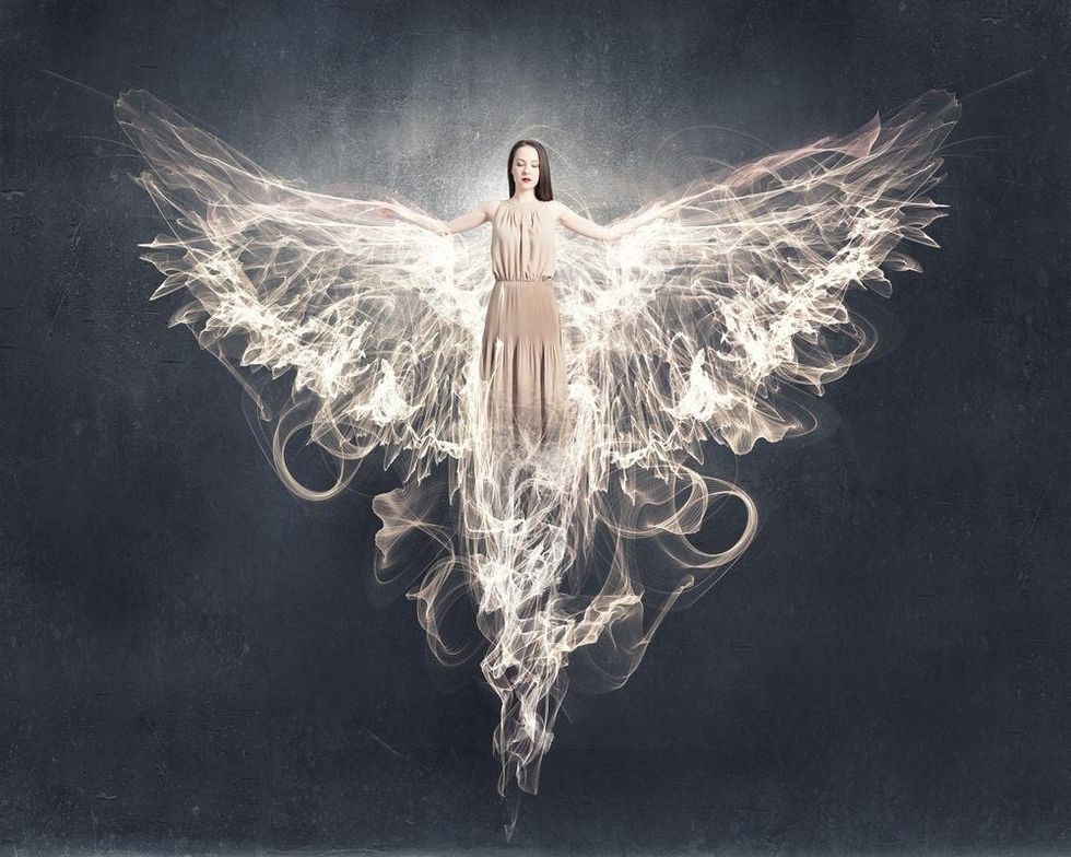 Attractive woman with angel wings on sky