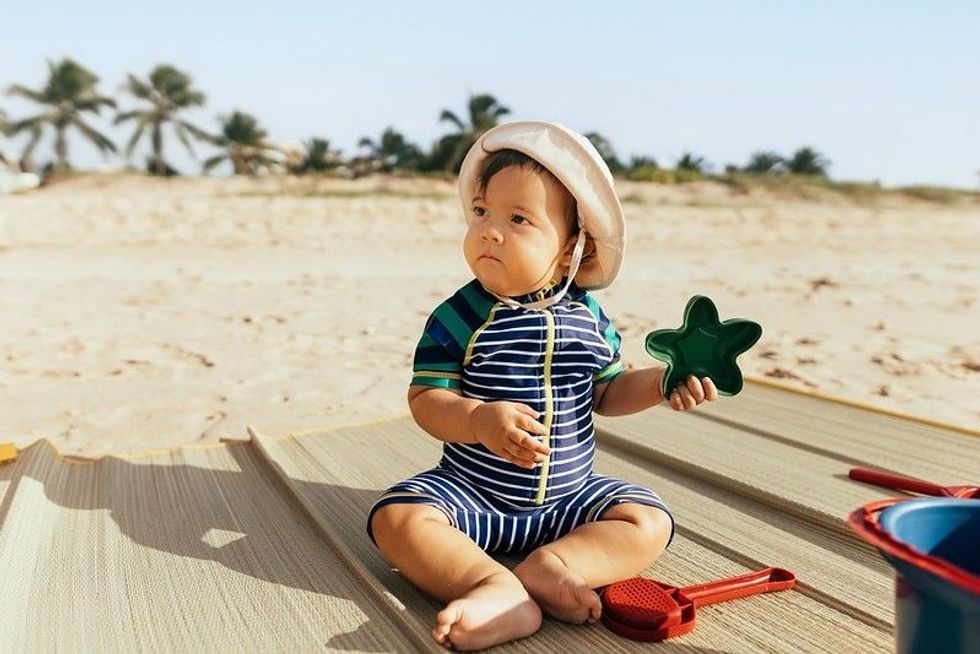 Baby boy playing in sand on a beach