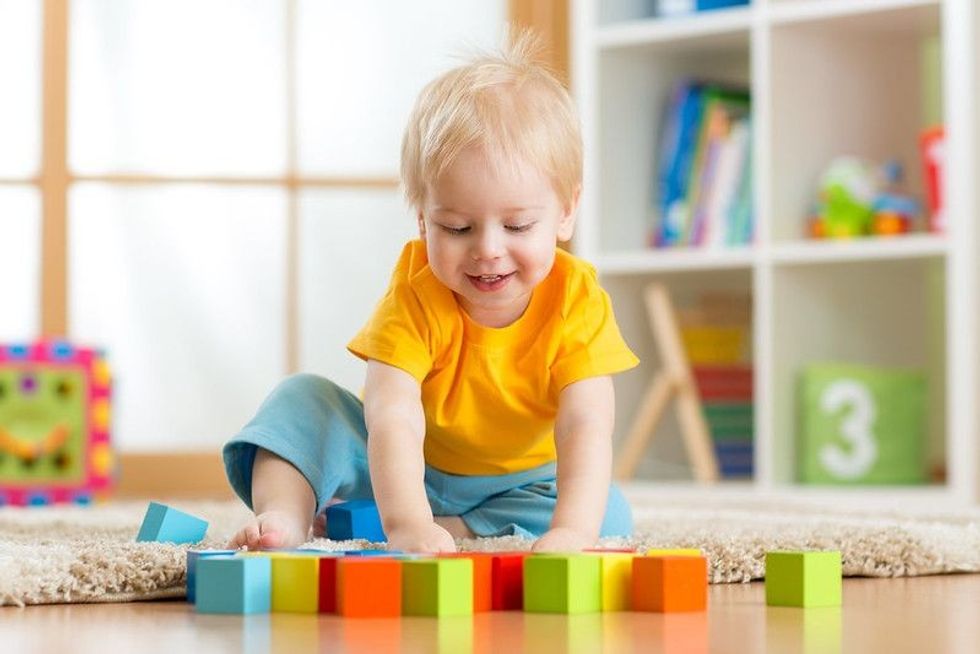 Baby boy playing with colorful wooden blocks