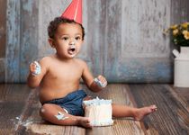 Baby boy playing with his birthday cake