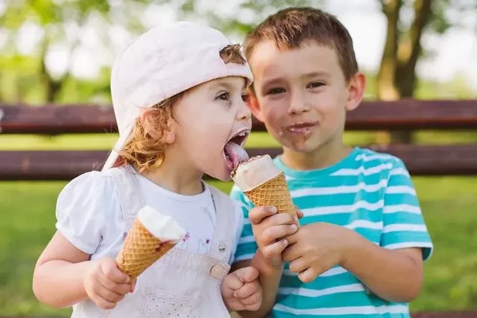 Baby boy shares an ice cream with his sister during the bank holiday weekend