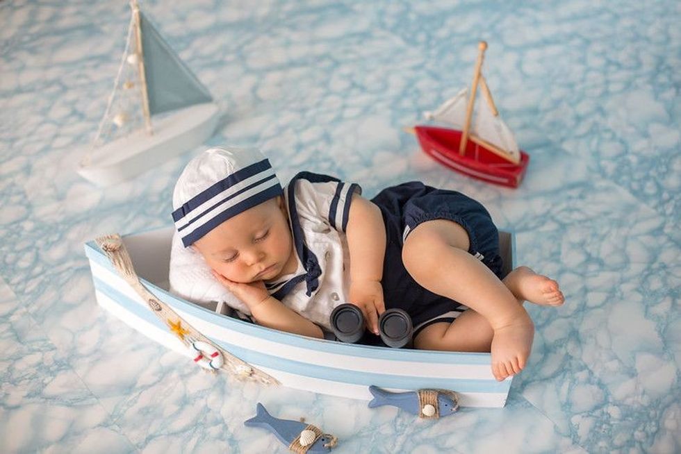 Baby boy sleeping in wooden boat