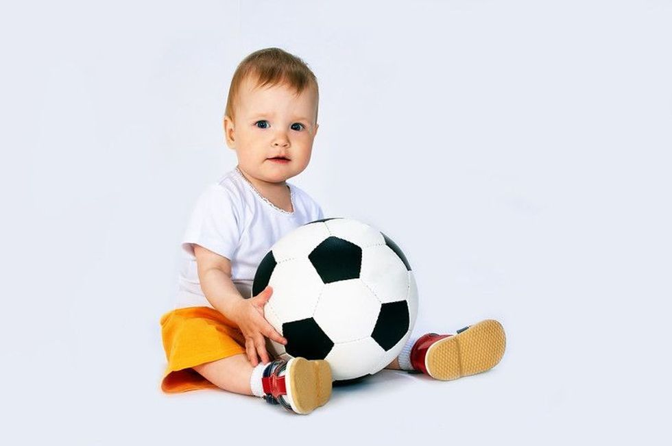 Baby holding football in hand