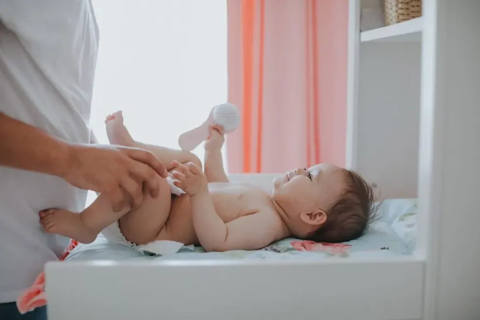 Baby lying on baby changing table