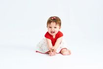 Baby sitting in red dress