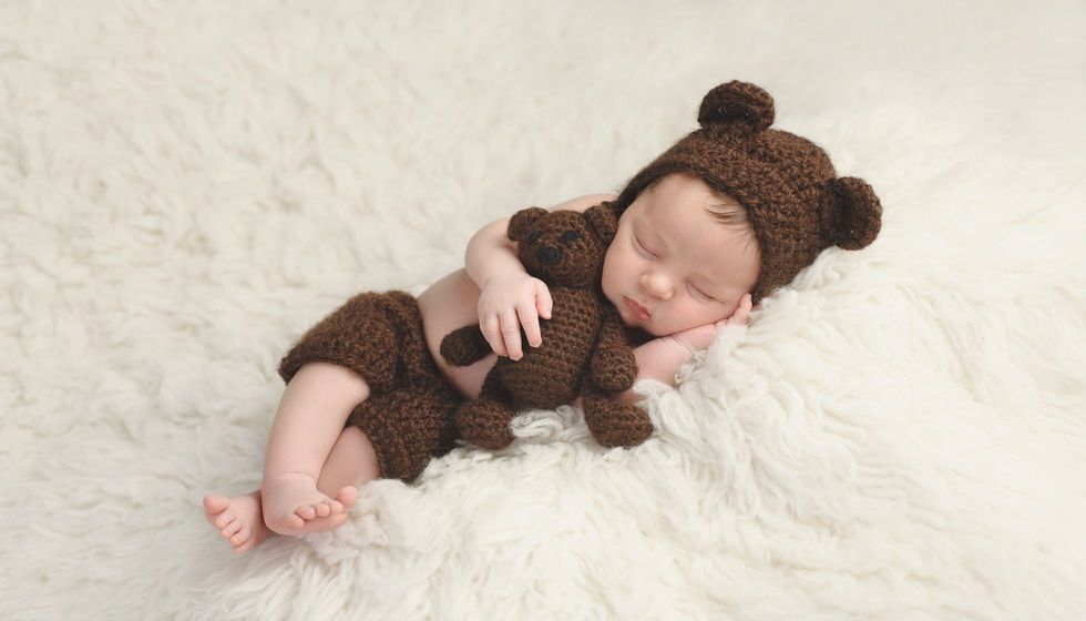Baby sleeping on a white flokati rug.