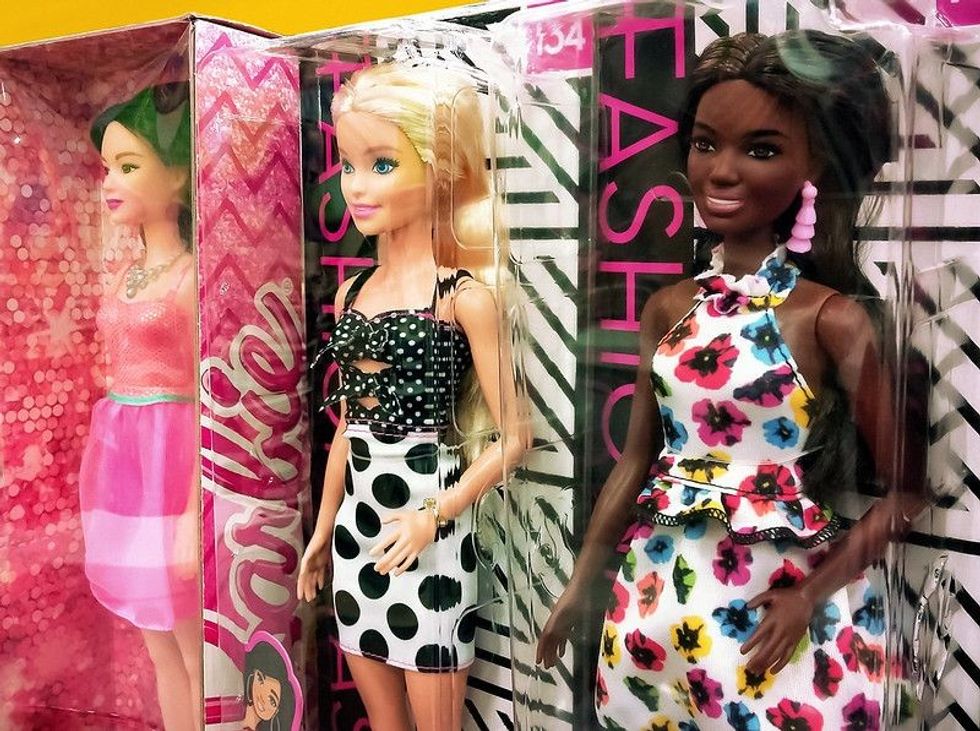 Barbie dolls of different races on a shelf