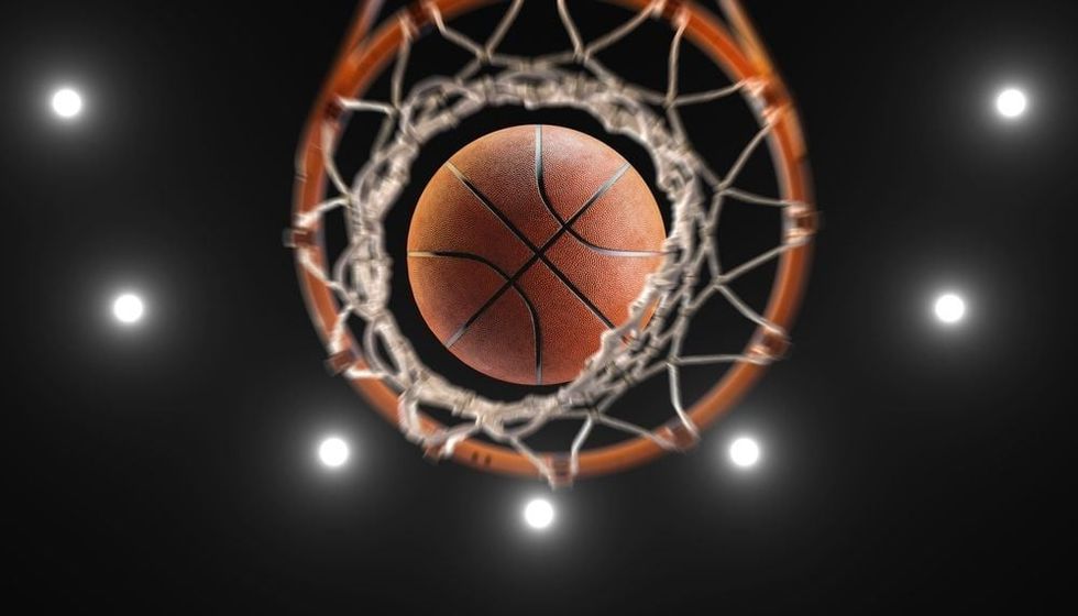 Basketball on hoop and lighting from roof stadium