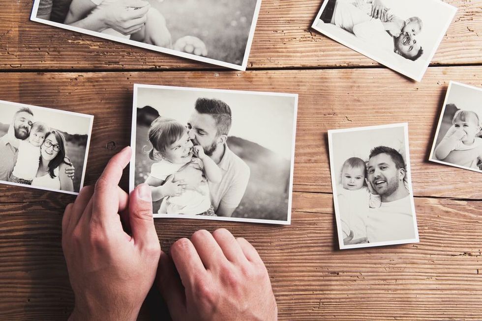 Black and white family photos laid on wooden floor background.