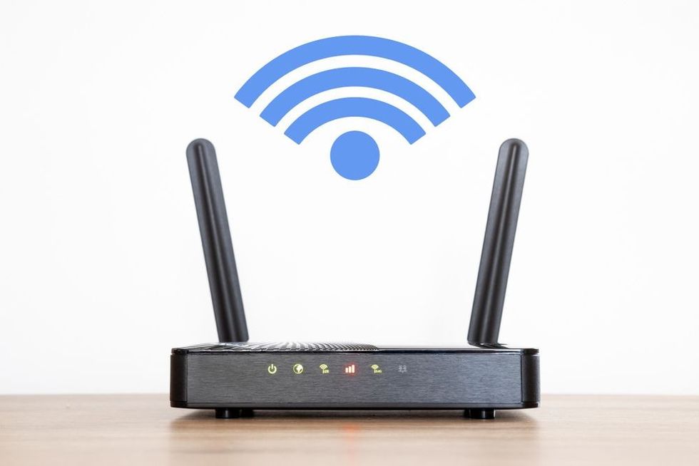 Black router and a blue wifi symbol on the wall