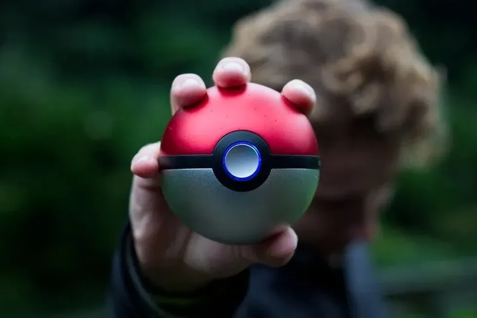 Boy holding out a Pokeball.