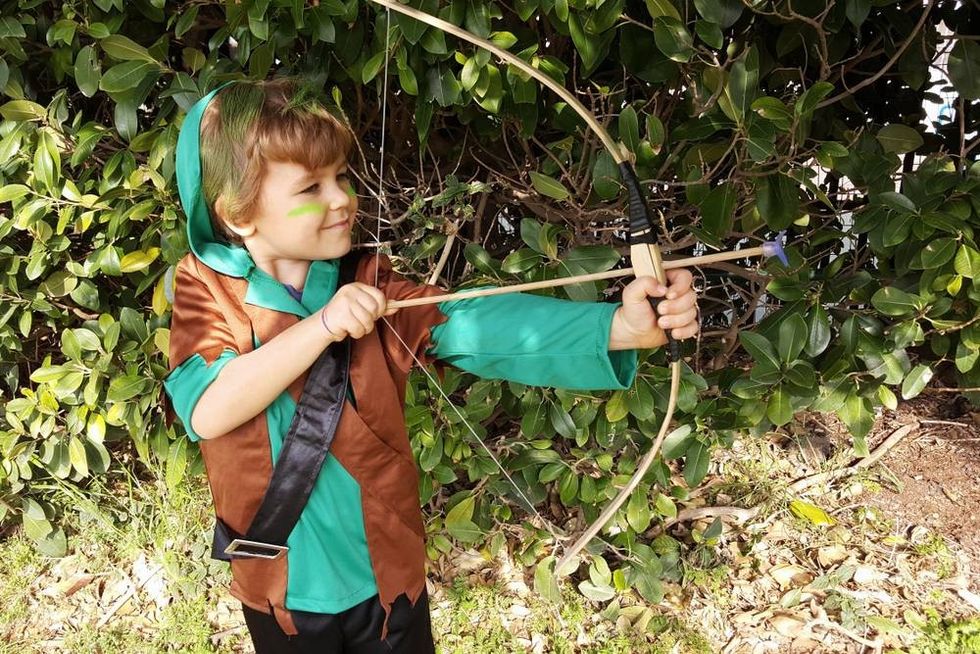 Boy playing outdoors with a bow
