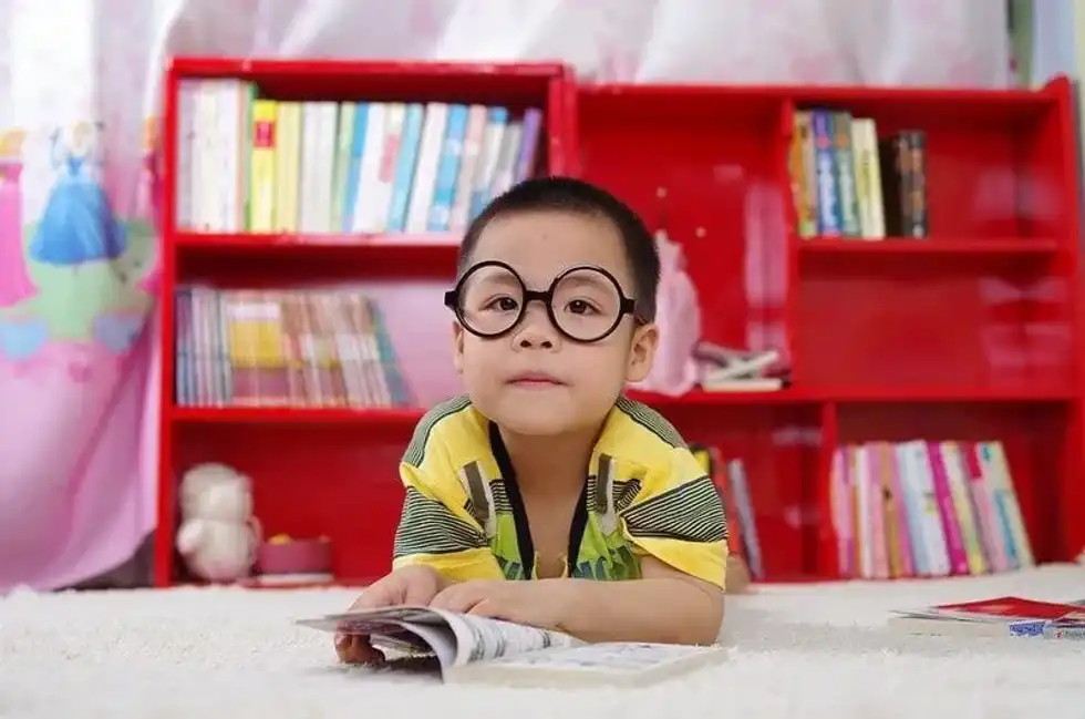 Boy reading on the floor following the Oxford reading tree