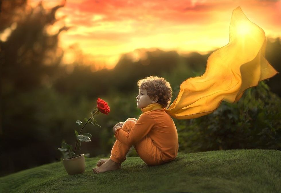 Boy sits with a rose flower