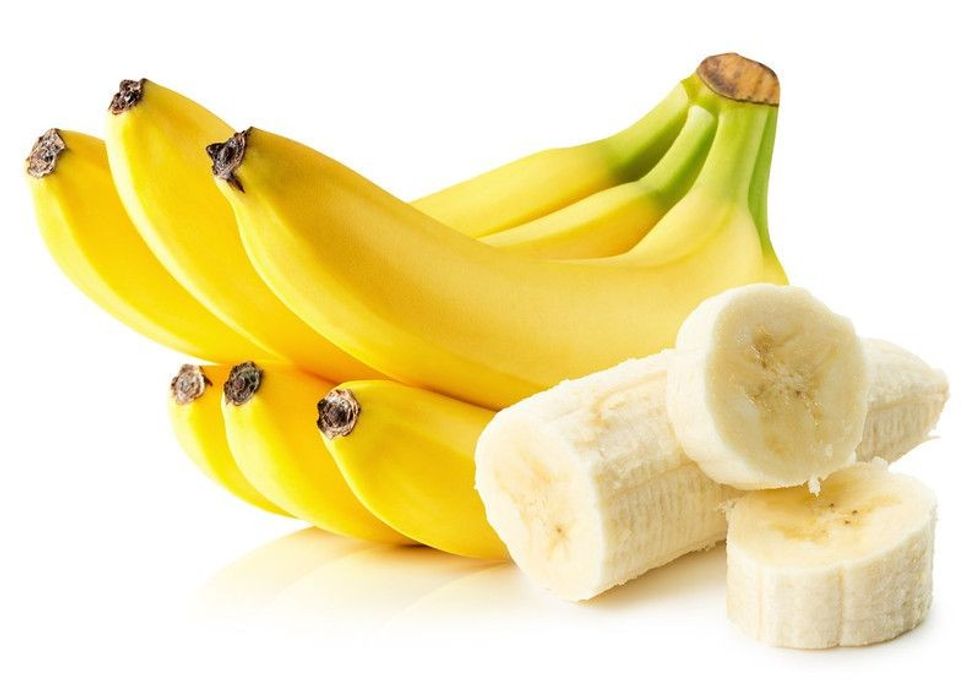 Bright yellow bananas with sliced banana pieces on white background.