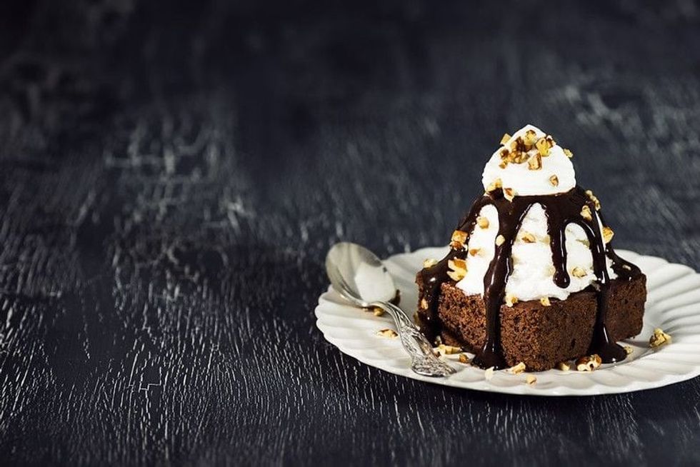 Brownie Sundae with a Scoop of Vanilla Ice Cream, Chocolate Sauce, Whipped Cream, and Nuts.