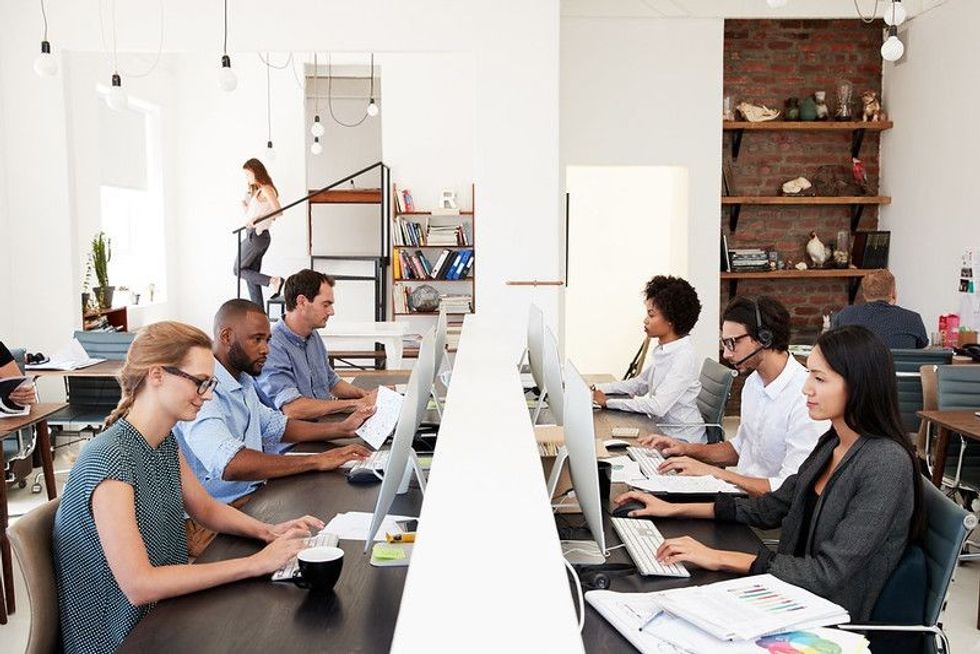 Business colleagues working at a busy open plan office.
