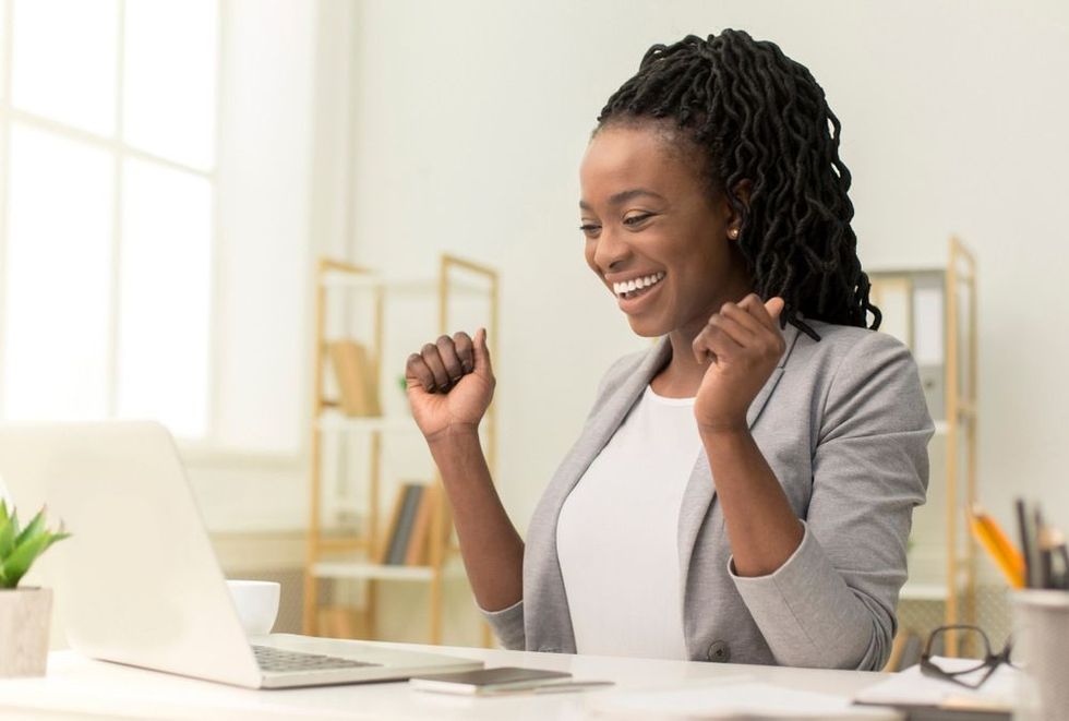 Business woman happy with success and is seen smiling at the laptop