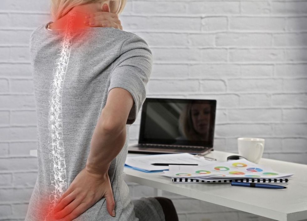 Business Woman suffering from back pain:Incorrect sitting posture problems. 