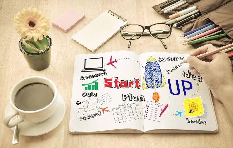 Businessman write Notebook word "Start up"