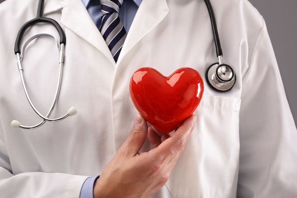 Cardiologist holding heart against chest
