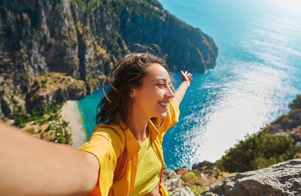 Carefree tourist woman taking picture outdoors for memories