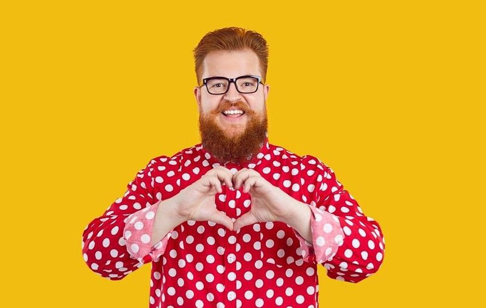Cheerful plus size man making love sign with hands.