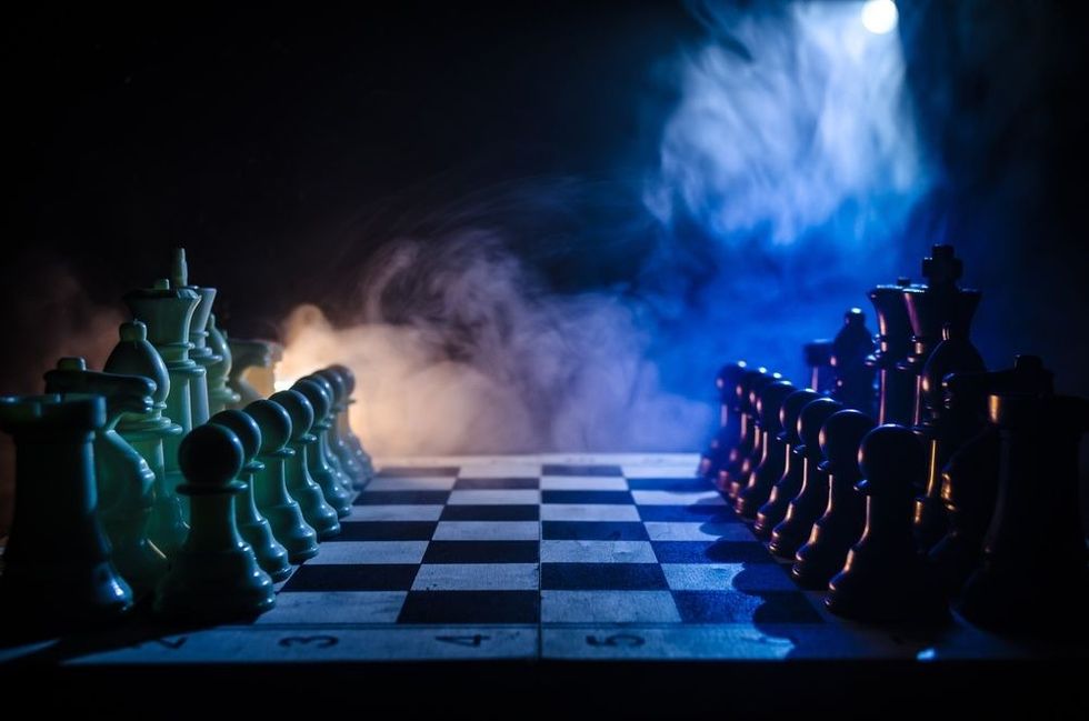 Chess figures on a dark background with smoke and fog.