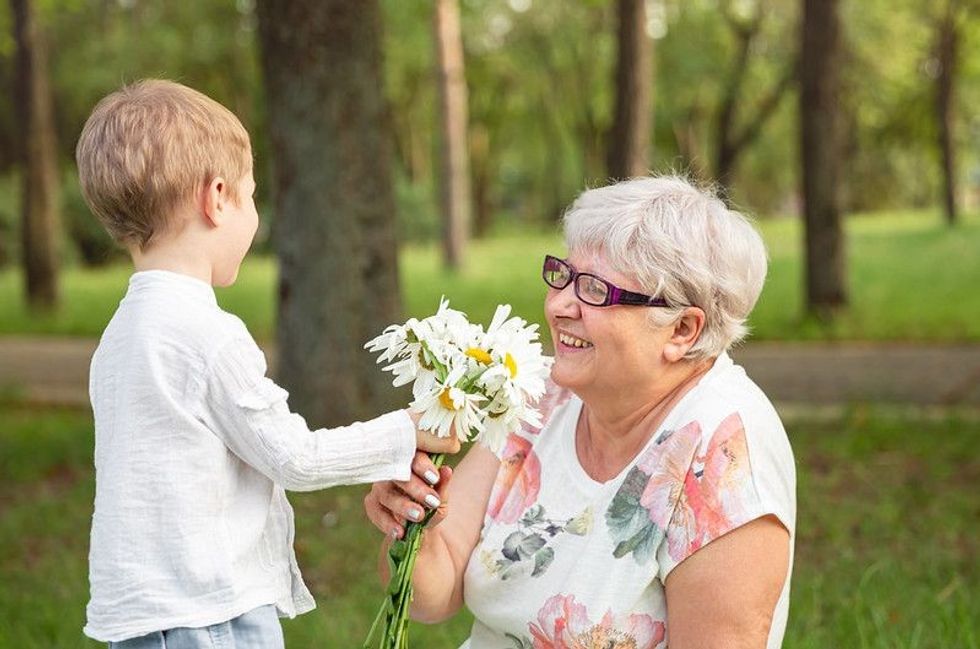 Child giving flowers to his grandma