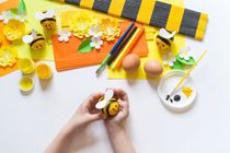 Child  painting an Easter egg yellow bee.