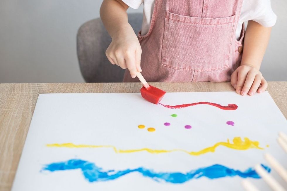 Child painting with colour ice cubes