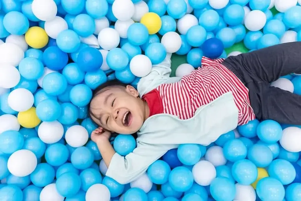 Child surrounded by glow in the dark bouncy balls you can make at home