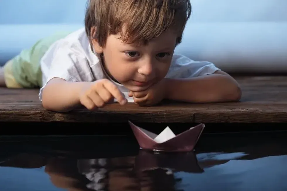 Child testing out their boat made from aluminium foil