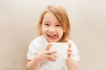 Child using a cup in tea staining experiment