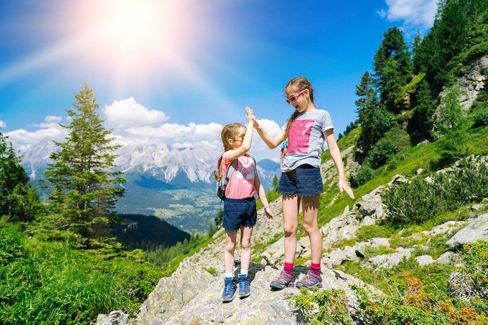 Children hiking mountains on a sunny day.